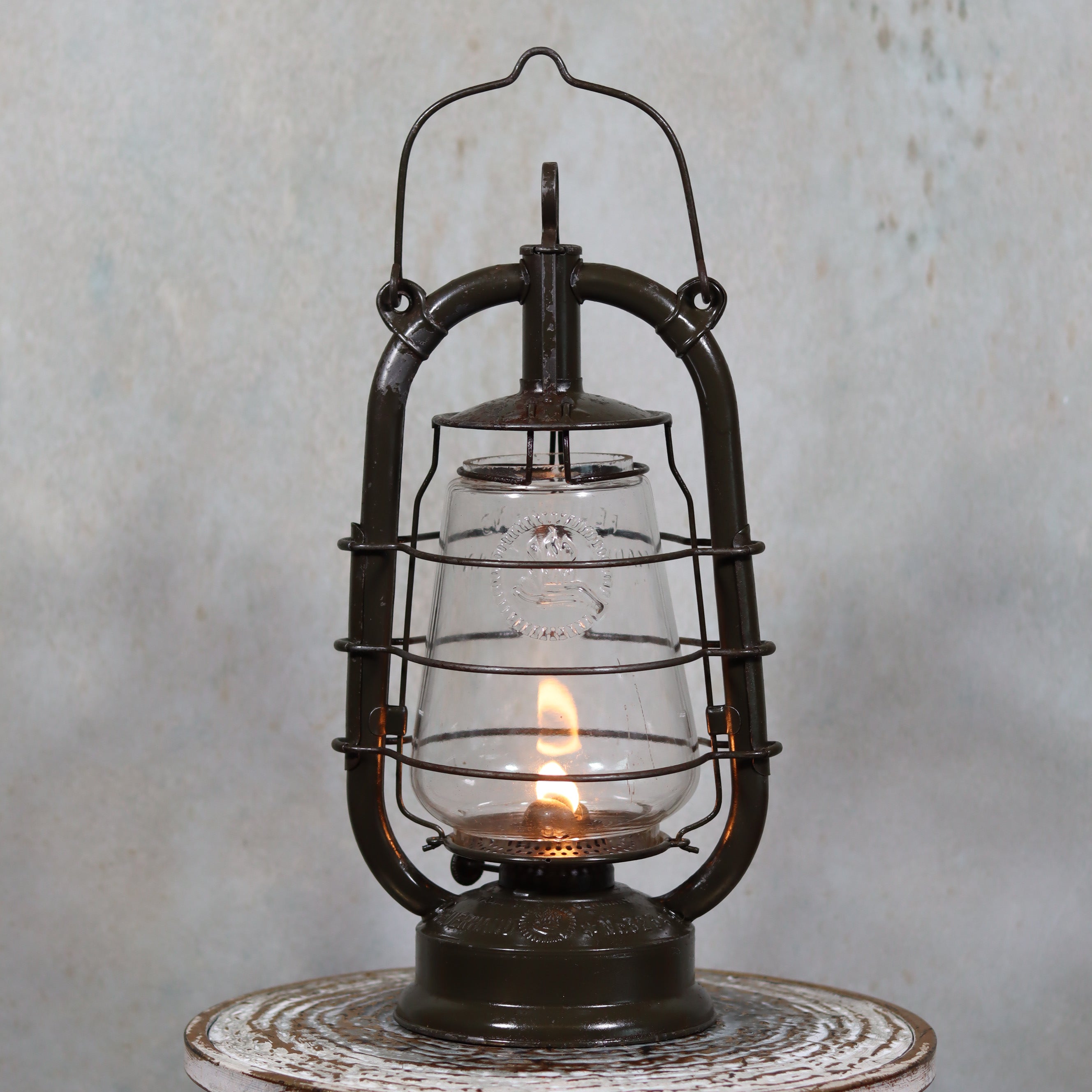 Vintage Feuerhand 323 Storm Lantern – Late 1930s, Original Paint & Embossed Glass oil lamp with lit flame and metal frame