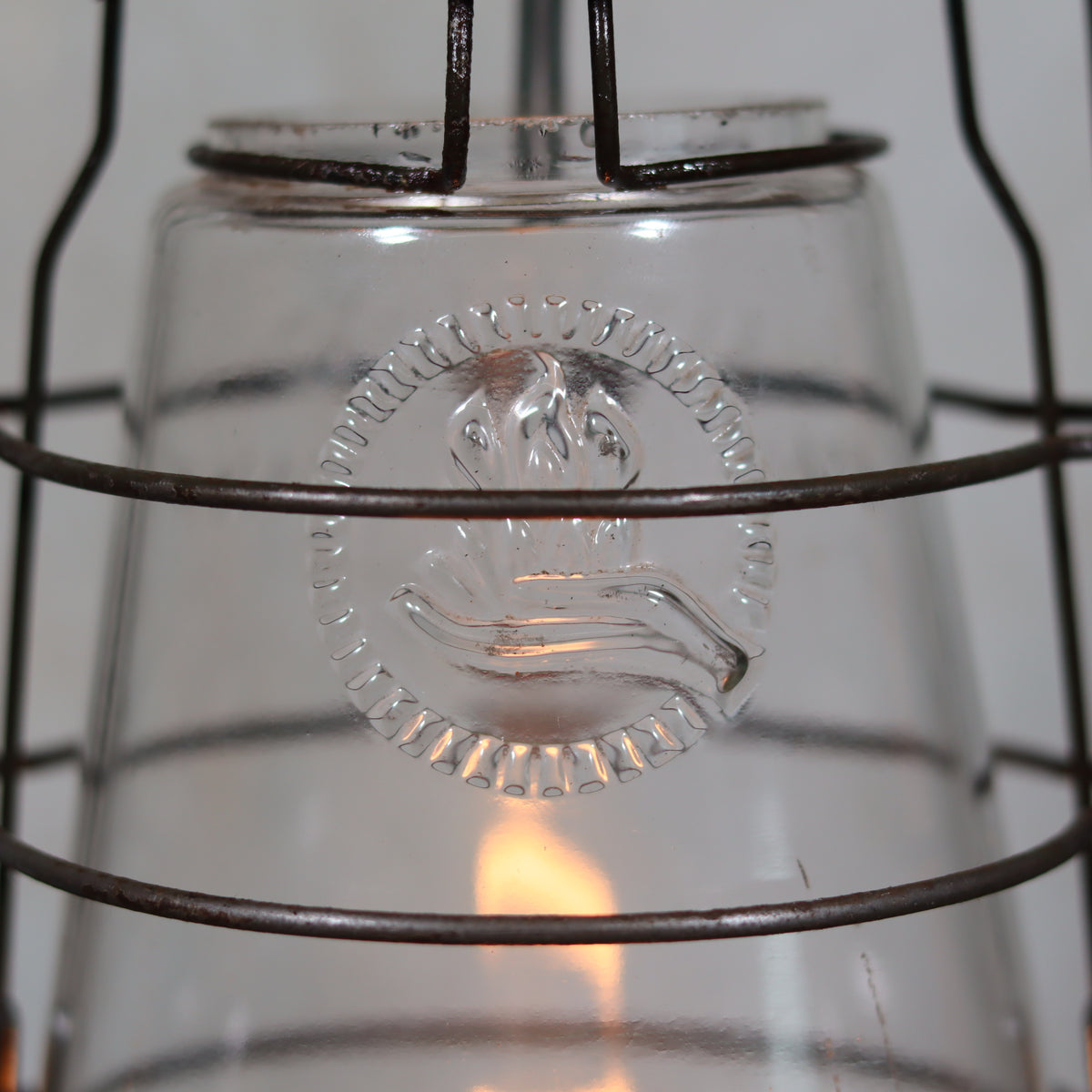Close-up of embossed glass on Vintage Feuerhand 323 Storm Lantern – Late 1930s, Original Paint with lit oil lamp inside