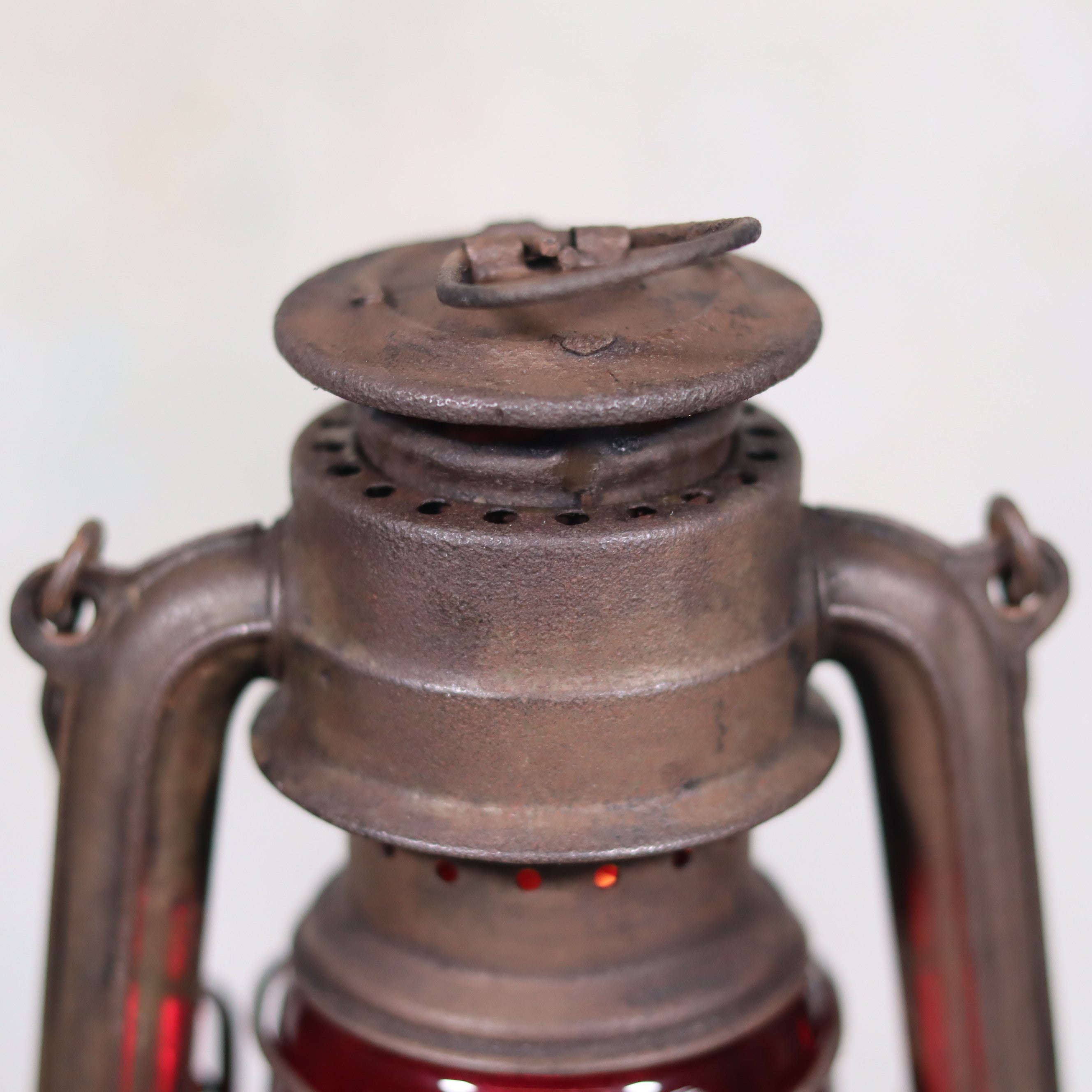 Close-up of rusted metal top of Vintage Pre-War Storm Lantern – Feuerhand 175 (1930s) with Red Glass oil lamp