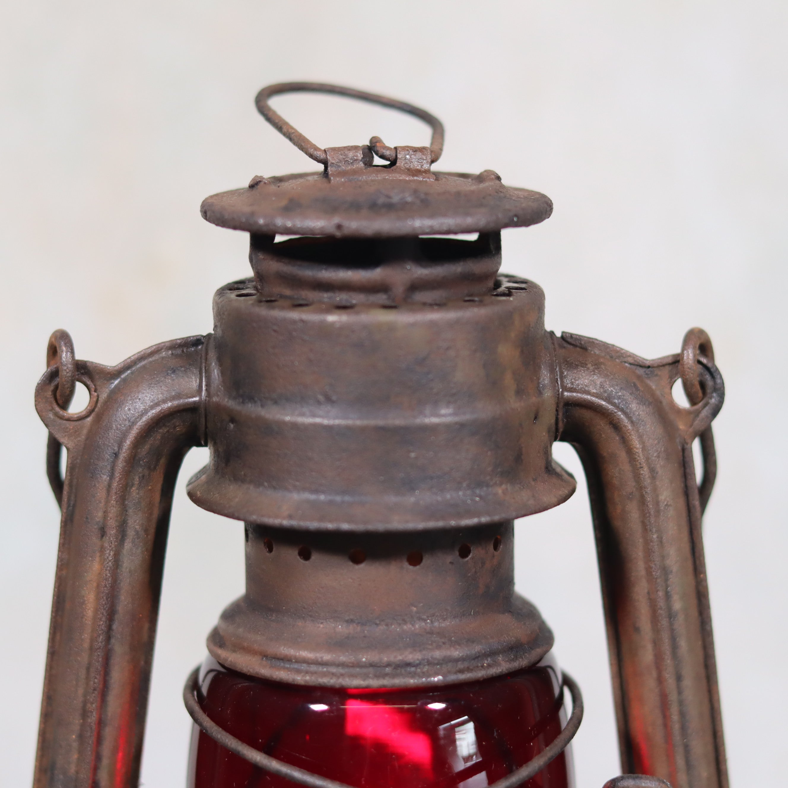 Vintage Pre-War Storm Lantern – Feuerhand 175 (1930s) with Red Glass showing detailed rusted metal top and handle