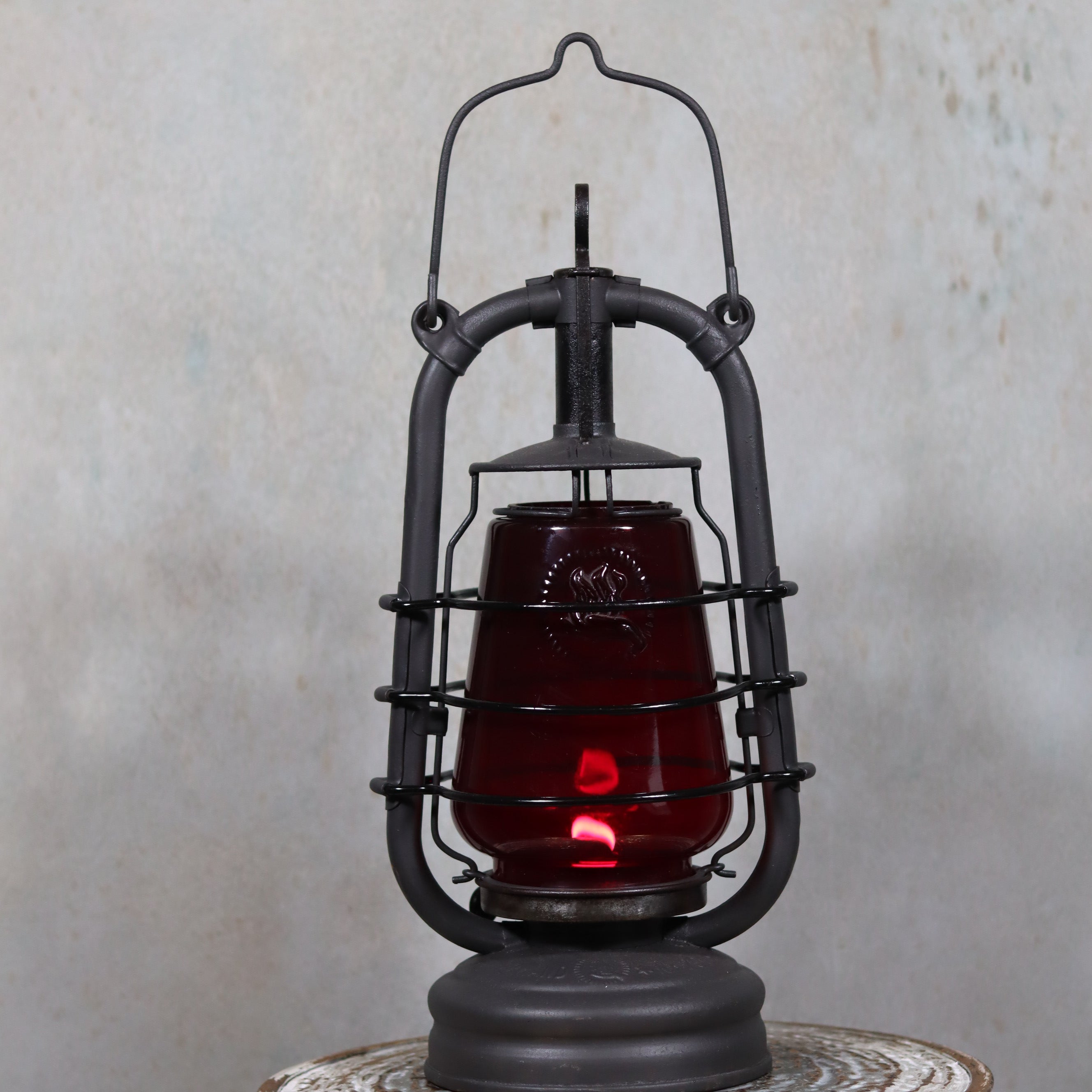 Beautiful Feuerhand 201 Storm Lantern – Germany, 1930s – With Rare Red Logo Glass oil lamp with protective metal frame and glowing flame