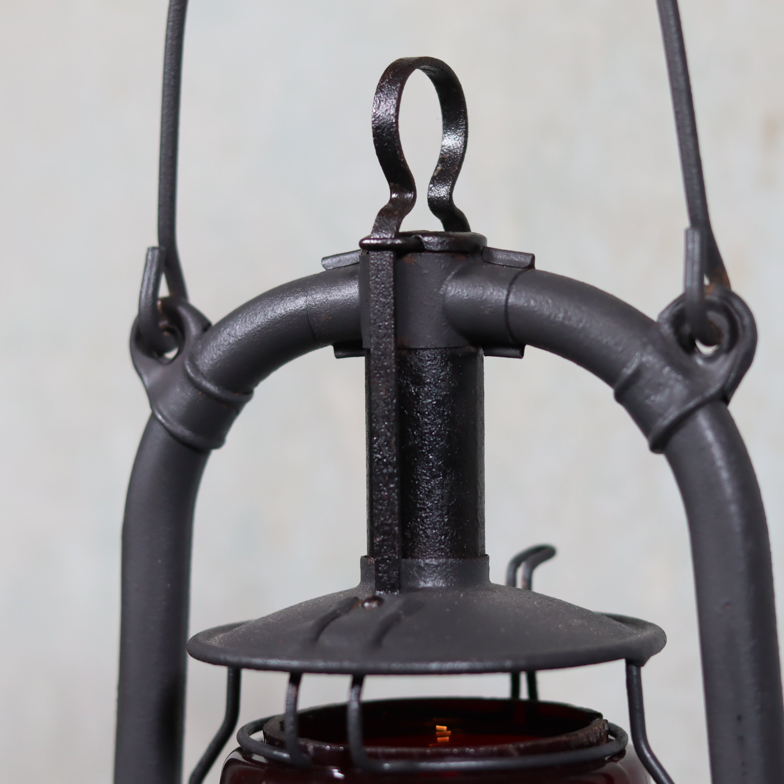 Beautiful Feuerhand 201 Storm Lantern – Germany, 1930s – close-up of metal handle and cap on rare red logo glass oil lamp