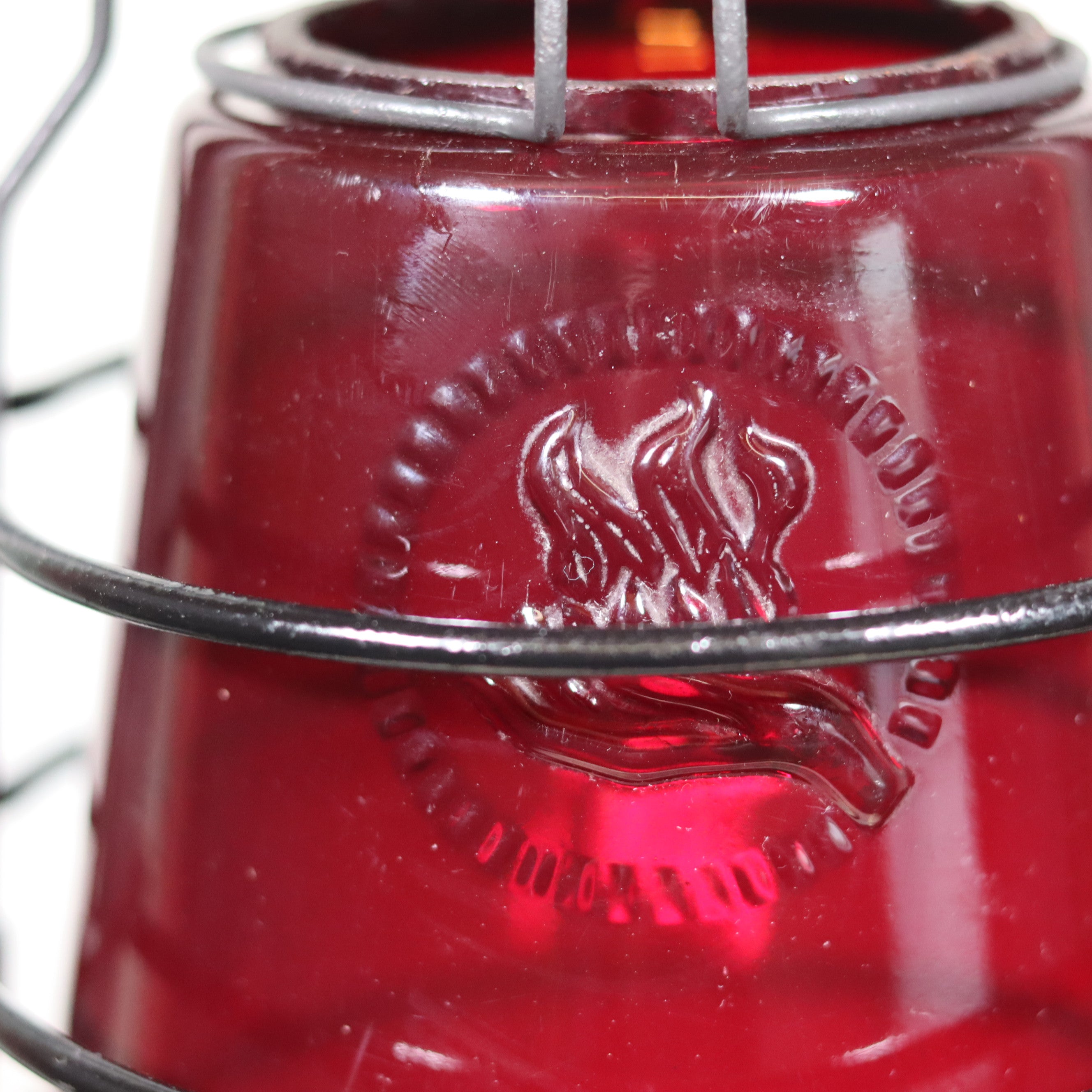 Close-up of the red glass with embossed logo on the Beautiful Feuerhand 201 Storm Lantern – Germany, 1930s design.