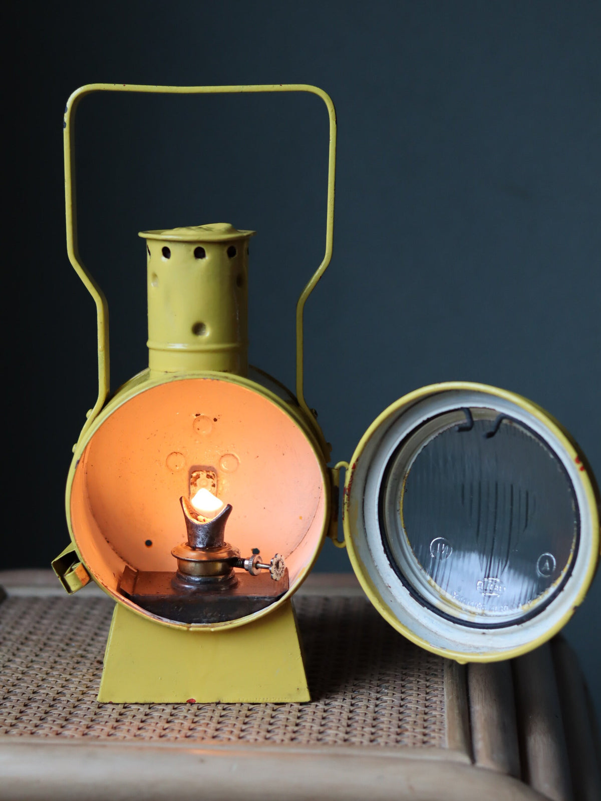 Vintage Dutch Railway Signal Lamp – NS Oil Lantern, 1930s, showing lit oil lamp inside classic yellow NS housing.