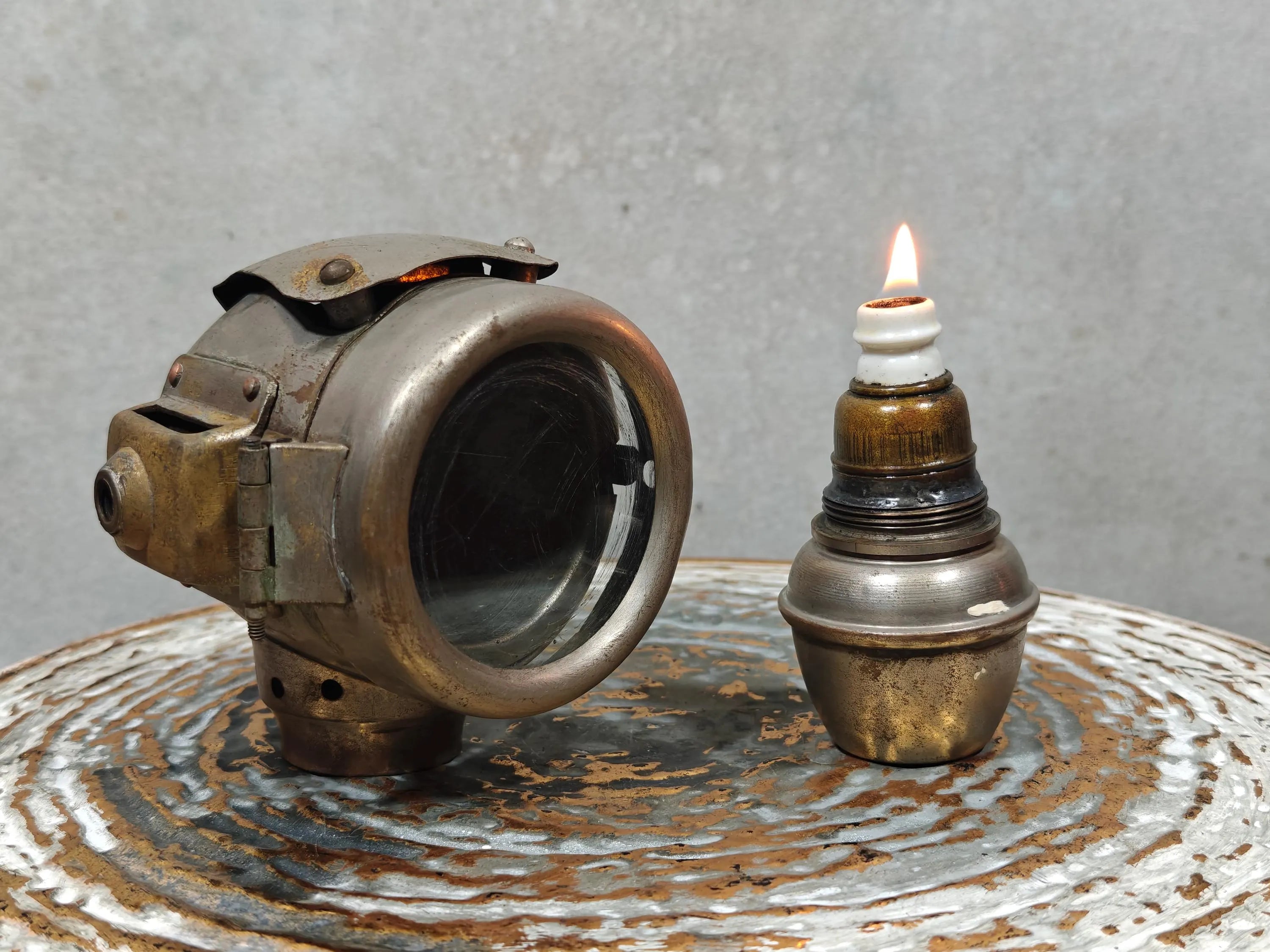 Rare Vintage Automobile Oil Lamp – French Side Lamp (1920s/30s) with lit vintage oil lamp and metal housing on textured surface