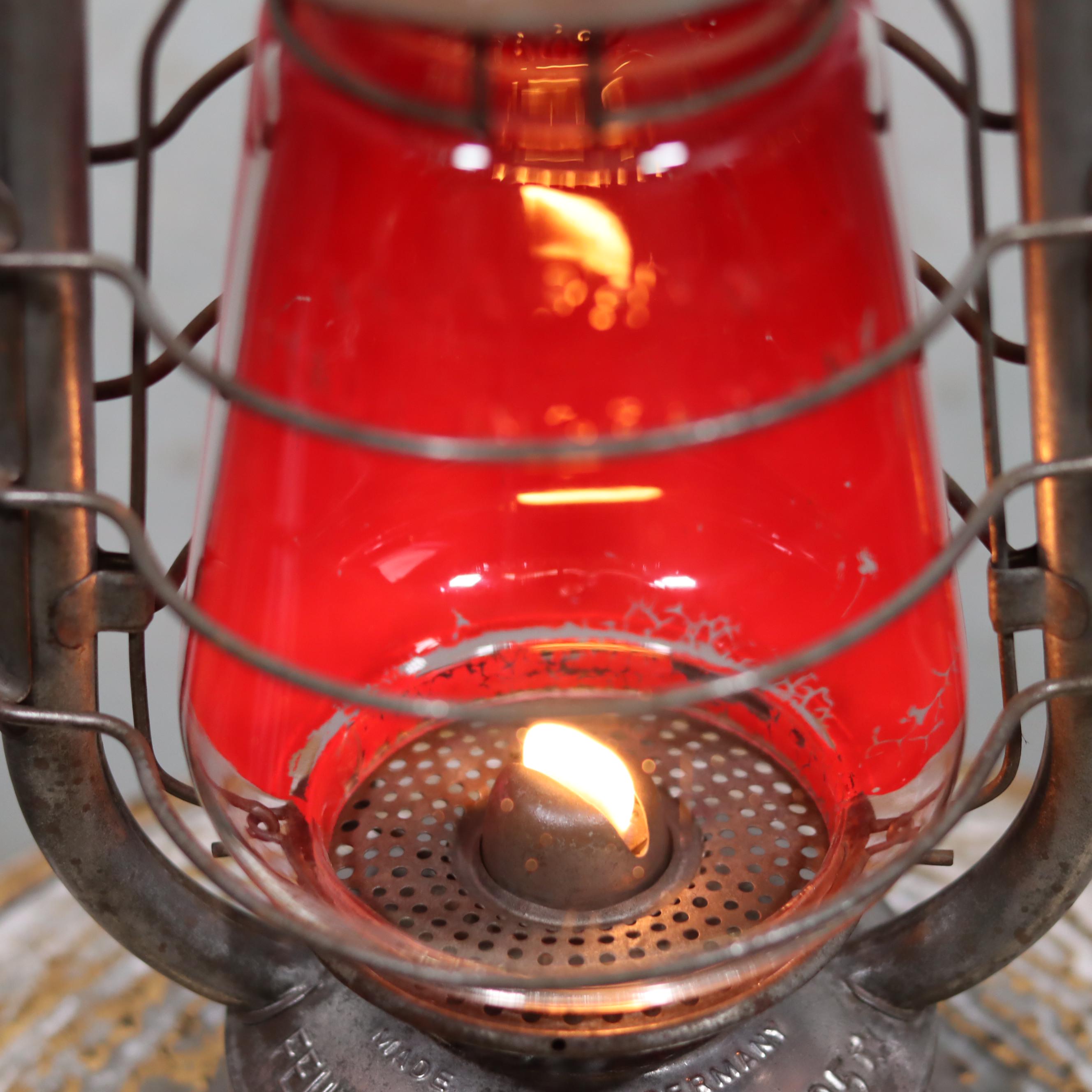 Rare Feuerhand 305 Hurricane Lantern – German Vintage Model (1930–1941) with glowing oil lamp flame inside red glass.