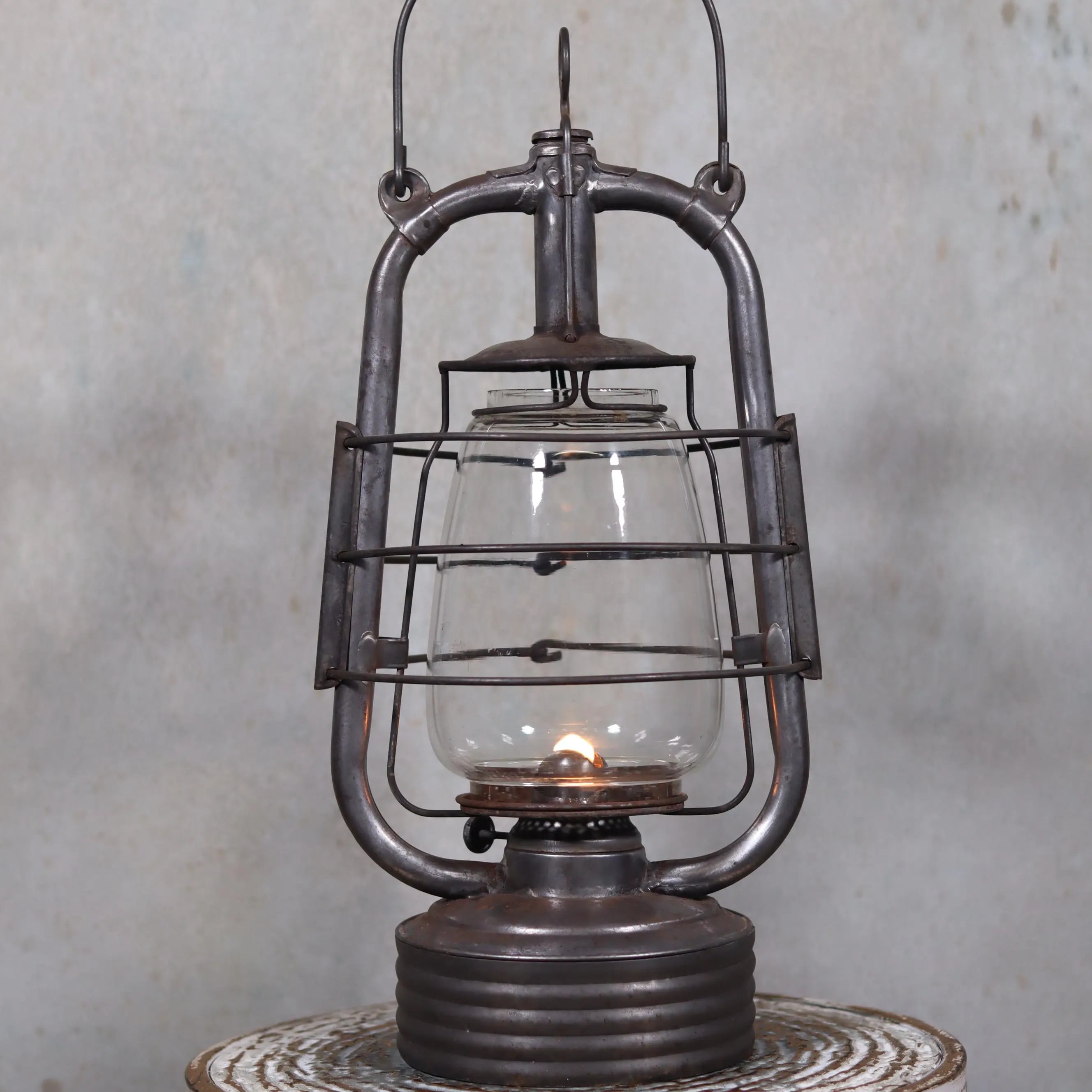 Vintage French Valentini Hurricane Lantern – La Bretonne Model (1950s/60s) oil lamp with metal frame and glass chimney lit on wooden surface