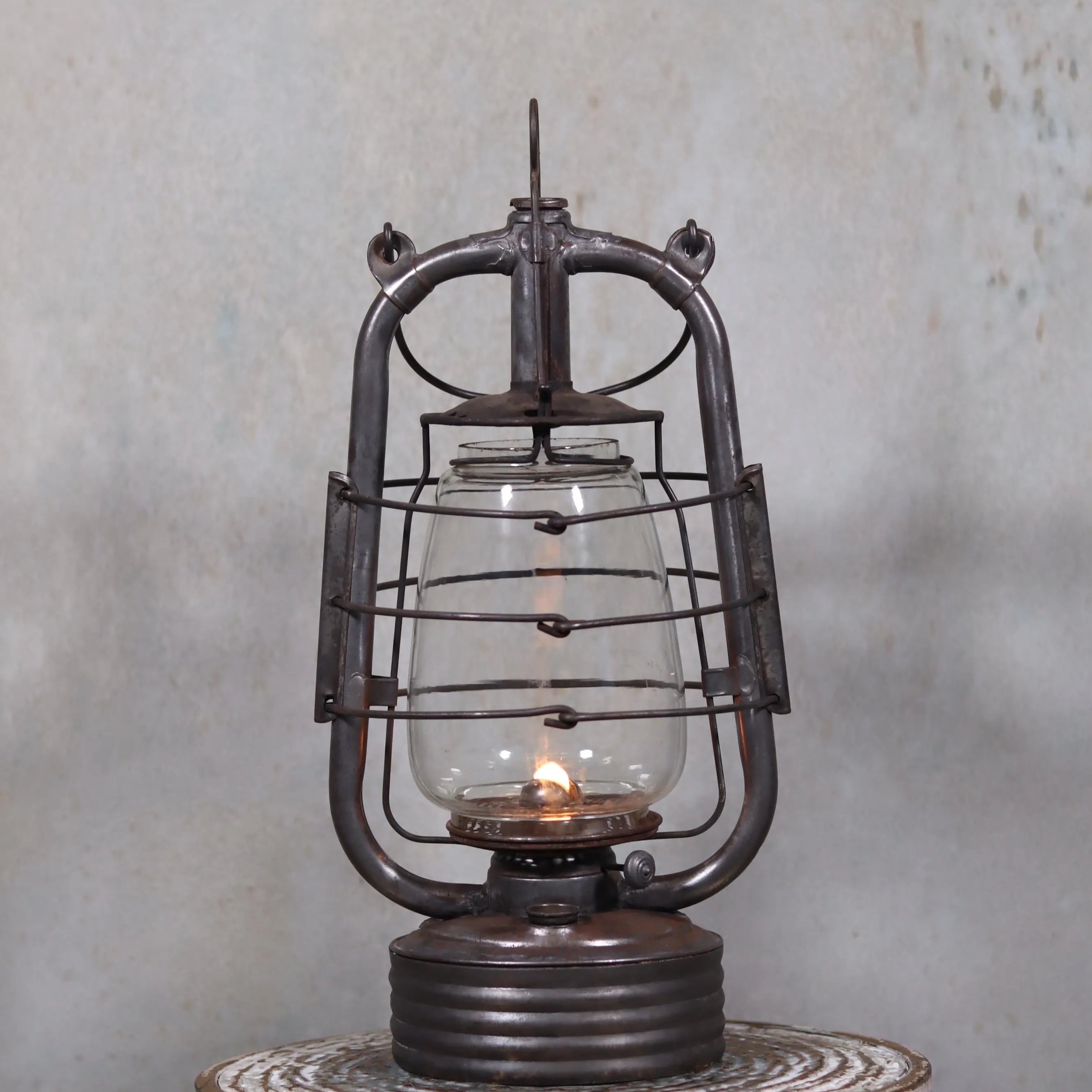 Vintage French Valentini Hurricane Lantern – La Bretonne Model (1950s/60s) oil lamp with protective metal frame and glowing flame.